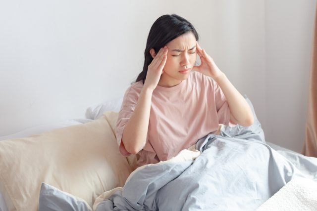 朝から頭の重さに悩む女性のイメージ