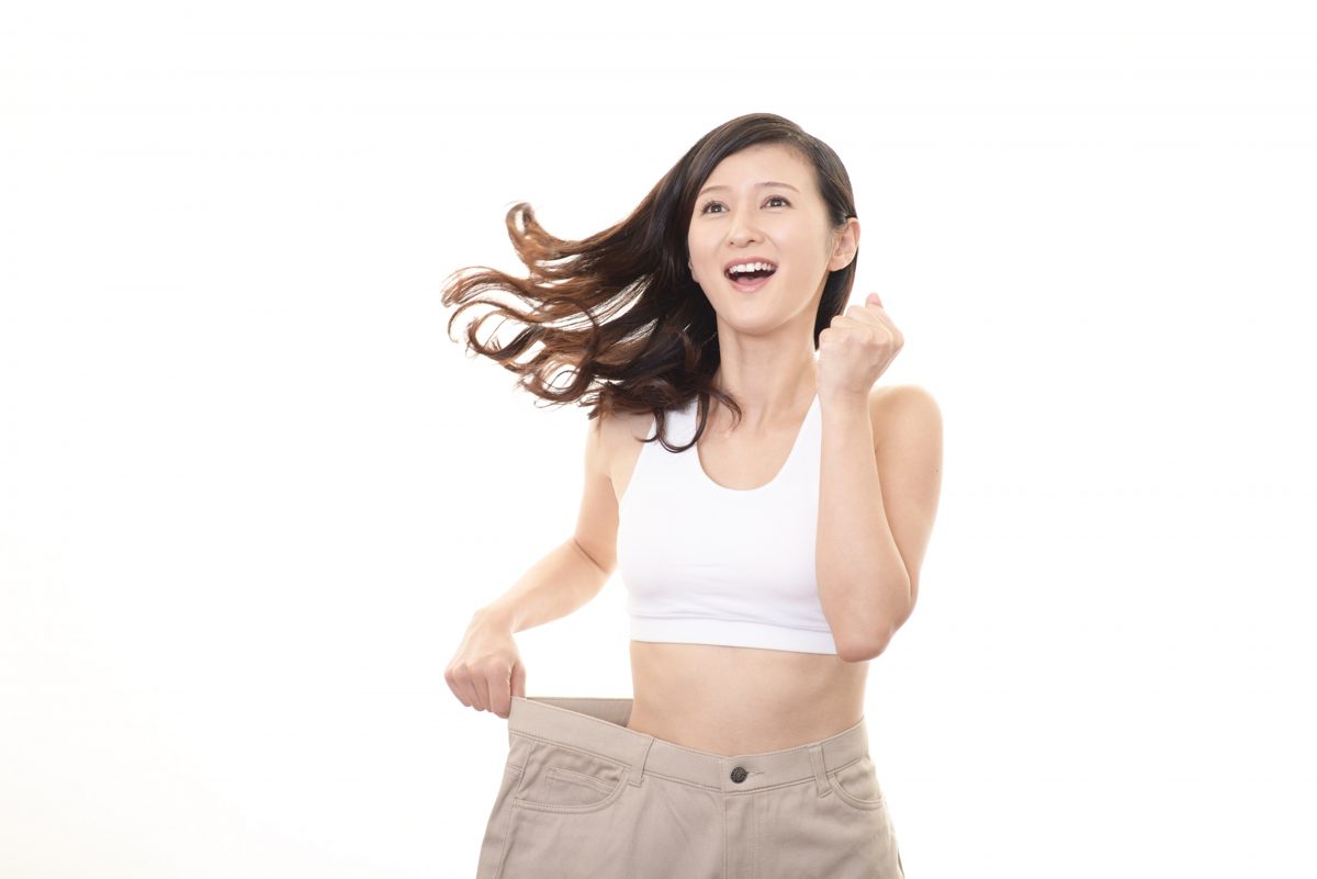 ズボンがゆるくなったことを喜ぶ女性のイメージ